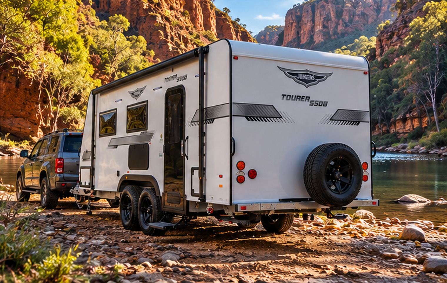 Jurgens Tourer caravan parked beside a river below red canyon cliffs