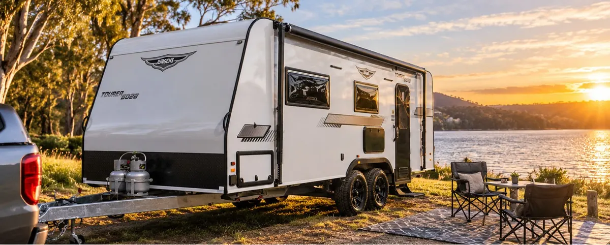 Jurgens Tourer 6028 caravan at a lakeside campsite at sunset